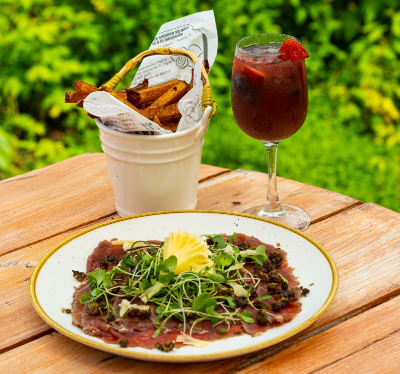 Le_Baluchon Éco-caféjuin_2021Gravlax de bœuf Highland rôti Copeaux de fromage québécois, câpres frits, jeunes pousses de salade et huile au thym citronnéeservi avec frites